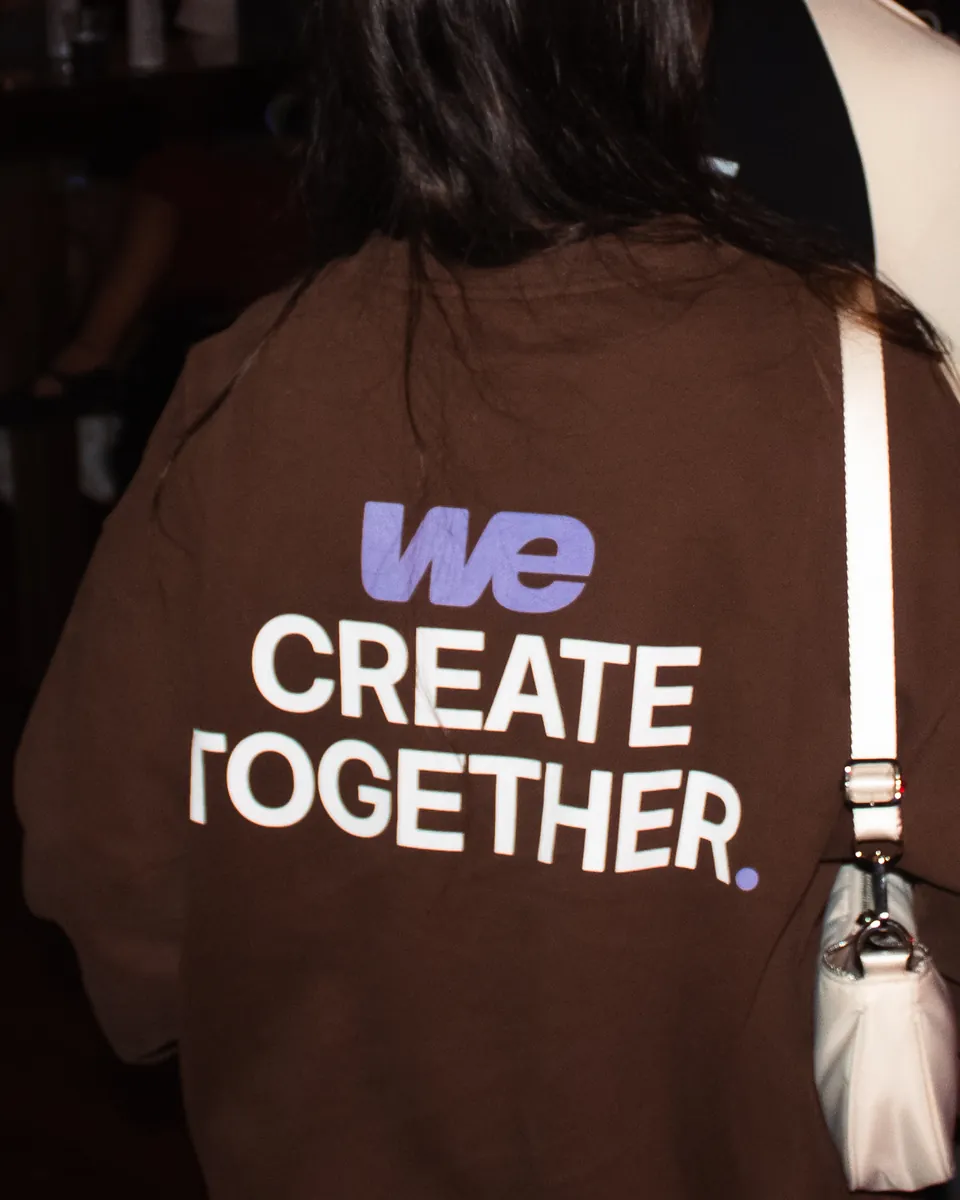 The back of the WE Pocket Crew in Cocoa on a night out: WE Create Together across the back