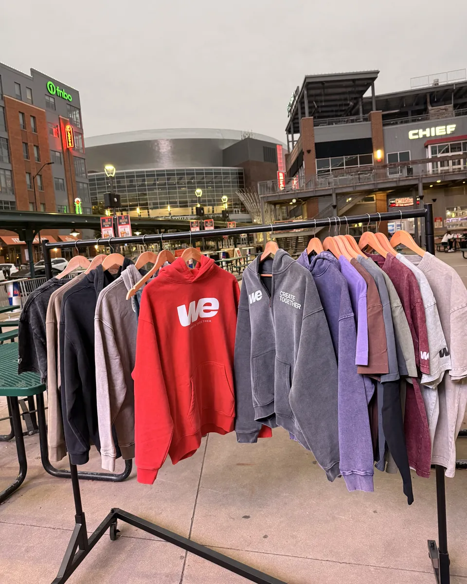 Drop 001 hoodies and tees on a rack outside the arena in the Railyard